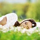 Meisje te slapen in het gras met bloemen
